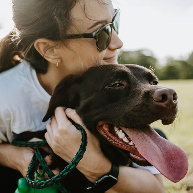 femme serrant un chien dans ses bras